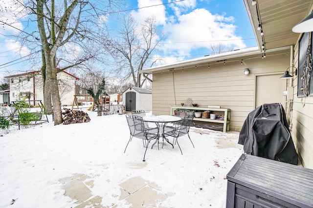 snow covered patio with a shed