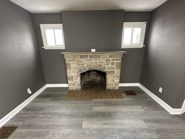 unfurnished living room with a fireplace and dark hardwood / wood-style floors