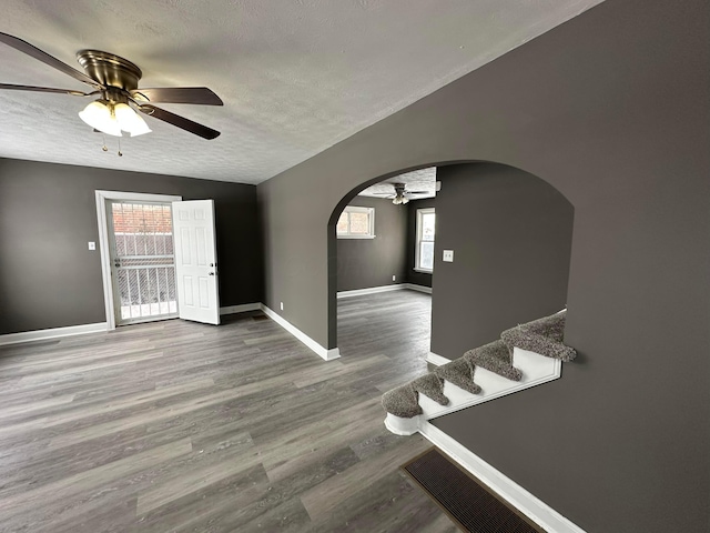 empty room with ceiling fan, hardwood / wood-style floors, and a textured ceiling