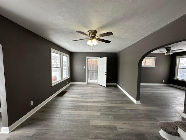 interior space featuring ceiling fan, dark hardwood / wood-style flooring, and a textured ceiling