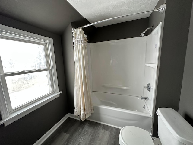 bathroom featuring wood-type flooring, a textured ceiling, toilet, and shower / bath combination with curtain