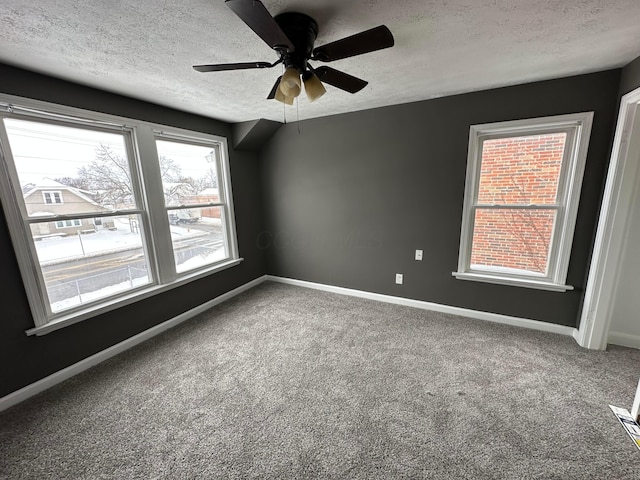 carpeted empty room featuring ceiling fan and a textured ceiling