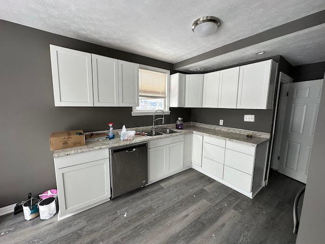 kitchen featuring dishwasher, dark hardwood / wood-style floors, sink, white cabinetry, and a textured ceiling