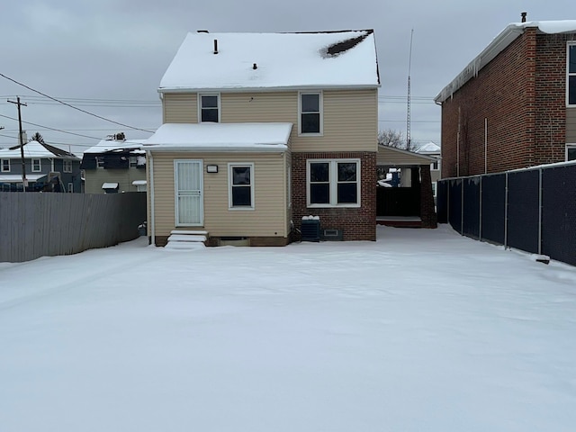 snow covered property with a carport