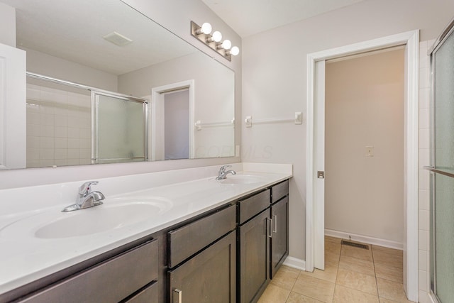 bathroom with a stall shower, tile patterned flooring, visible vents, and a sink