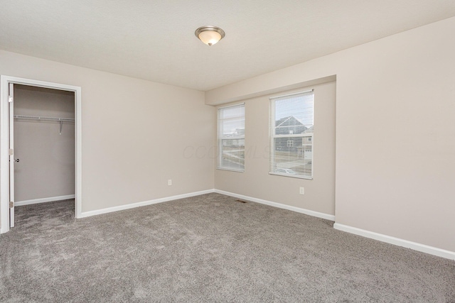 unfurnished bedroom with carpet, a closet, and baseboards