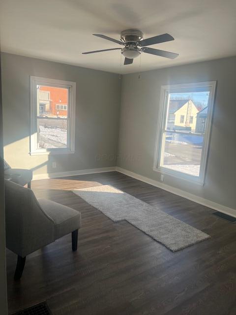 spare room with dark hardwood / wood-style flooring and ceiling fan