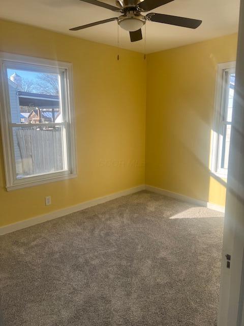 spare room featuring carpet flooring and ceiling fan