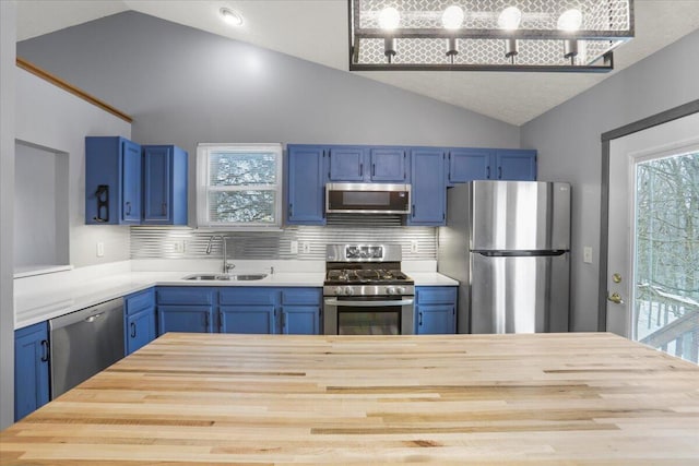 kitchen with tasteful backsplash, appliances with stainless steel finishes, sink, and blue cabinets