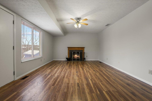 unfurnished living room featuring a textured ceiling, dark wood-type flooring, and ceiling fan