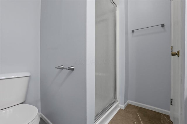 bathroom with toilet, tile patterned flooring, and an enclosed shower