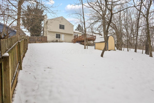 yard layered in snow featuring a storage unit