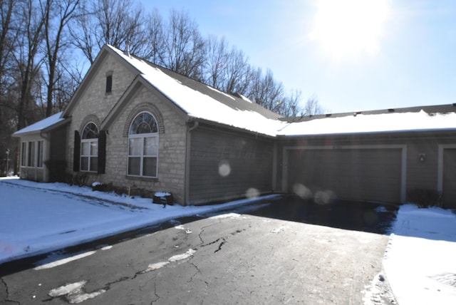 snow covered property with a garage