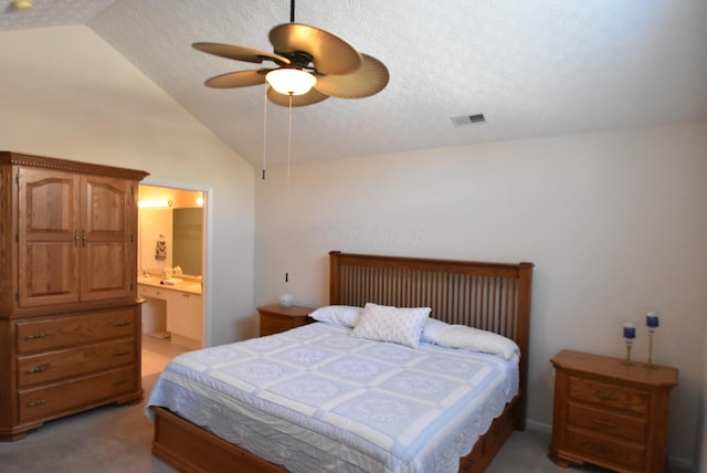 carpeted bedroom with a textured ceiling, connected bathroom, ceiling fan, and lofted ceiling