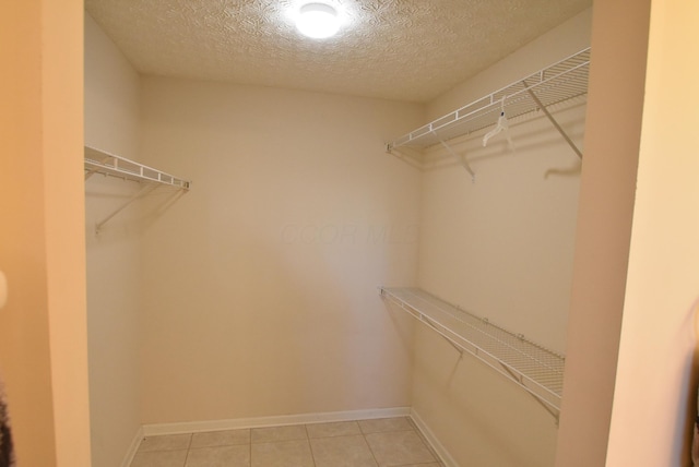 walk in closet with light tile patterned floors