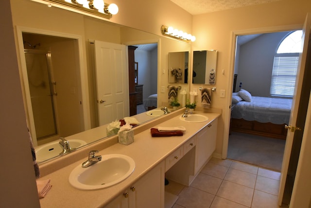 bathroom featuring tile patterned floors, vanity, a shower with door, and a textured ceiling