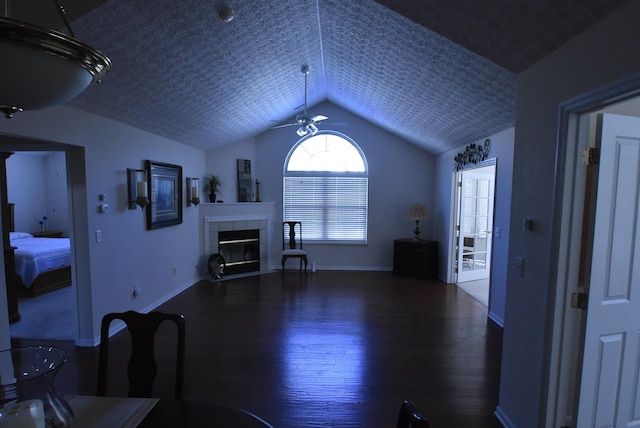 living room featuring a tile fireplace, ceiling fan, dark hardwood / wood-style floors, a textured ceiling, and lofted ceiling