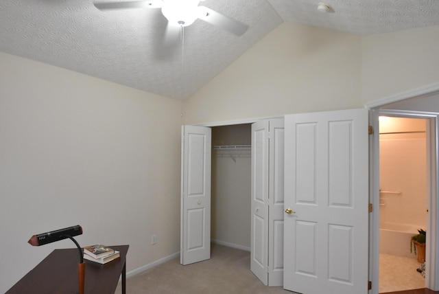 bedroom featuring light carpet, a textured ceiling, vaulted ceiling, and ceiling fan