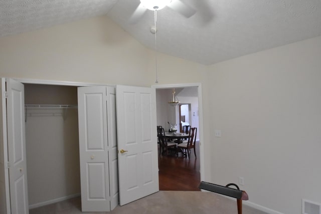 bedroom featuring carpet flooring, ceiling fan, a textured ceiling, and vaulted ceiling