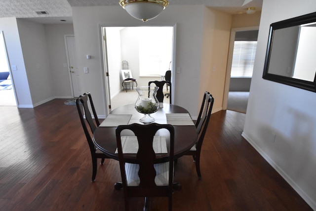 dining area with dark hardwood / wood-style flooring and a textured ceiling