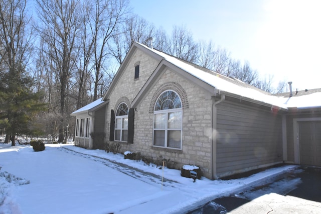 snow covered property with a garage