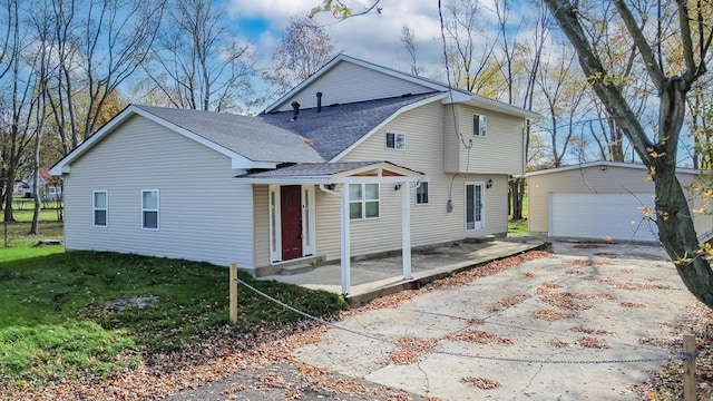 view of front of home with a front yard, an outdoor structure, and a garage