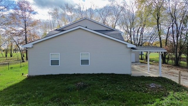 view of side of home featuring a yard and a carport