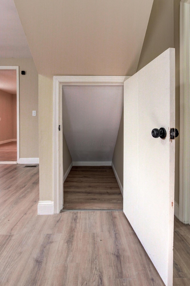 stairway featuring hardwood / wood-style flooring and lofted ceiling