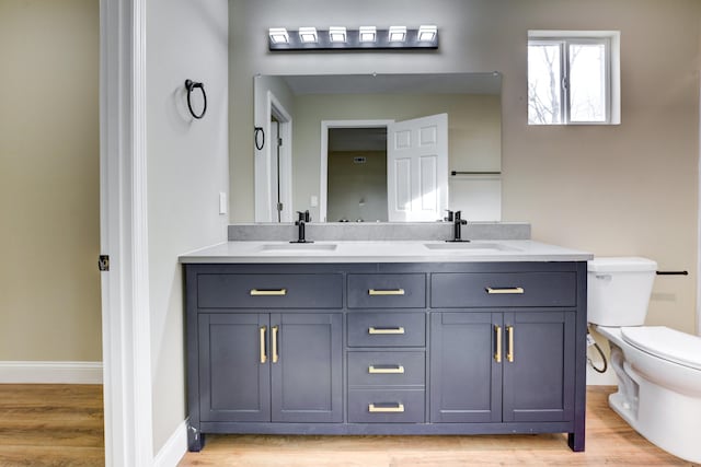 bathroom with vanity, hardwood / wood-style flooring, and toilet