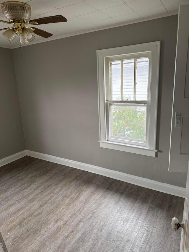 unfurnished room featuring a wealth of natural light, ceiling fan, hardwood / wood-style floors, and crown molding