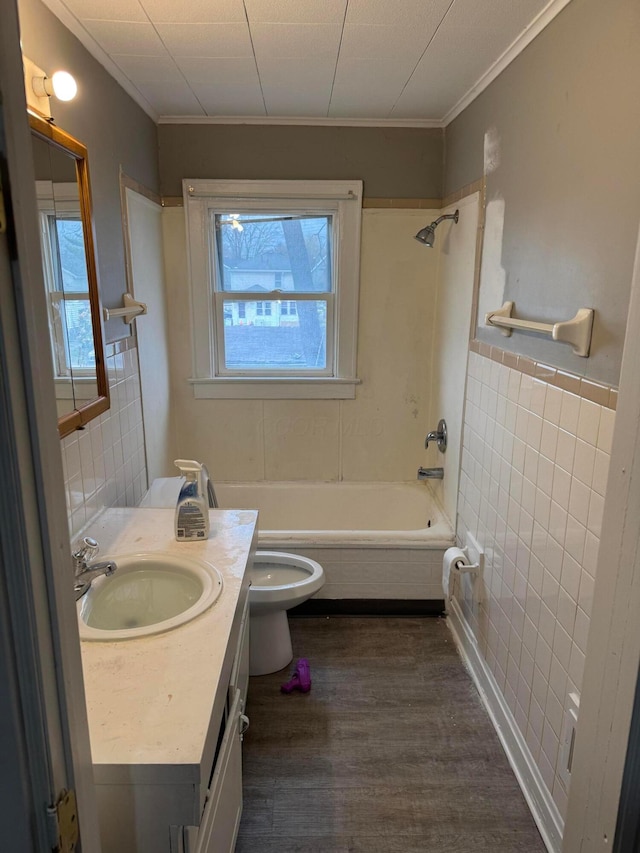 full bathroom with washtub / shower combination, wood-type flooring, toilet, vanity, and tile walls