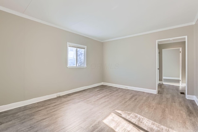 empty room featuring hardwood / wood-style floors and crown molding