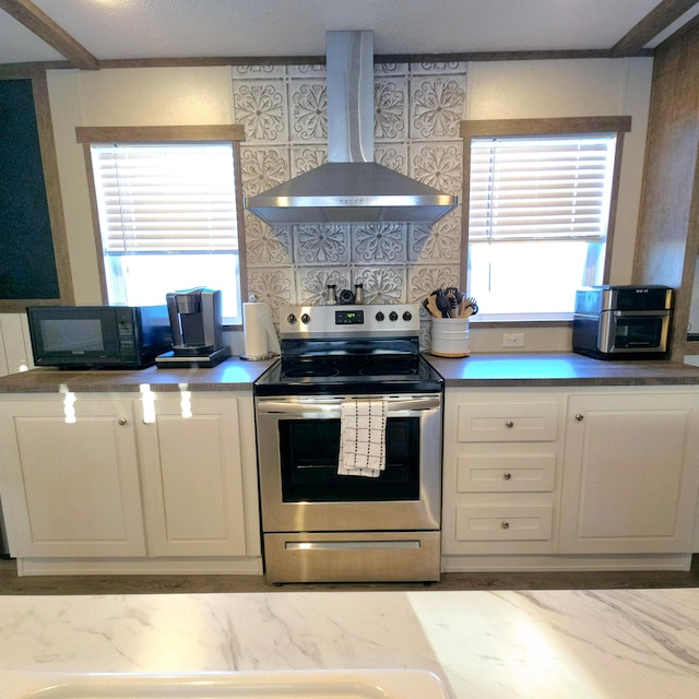 kitchen featuring stainless steel electric range, white cabinetry, backsplash, and wall chimney exhaust hood