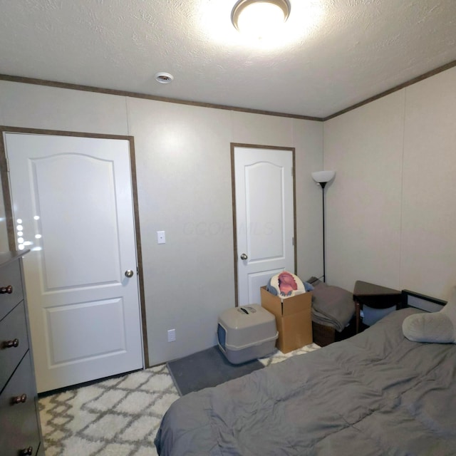 bedroom featuring ornamental molding and a textured ceiling