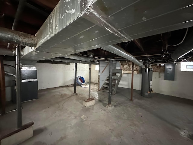 basement with heating unit, water heater, and electric panel