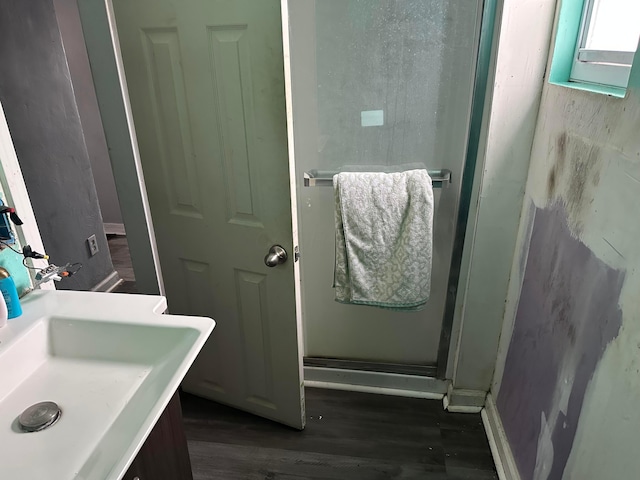 bathroom with sink, wood-type flooring, and an enclosed shower