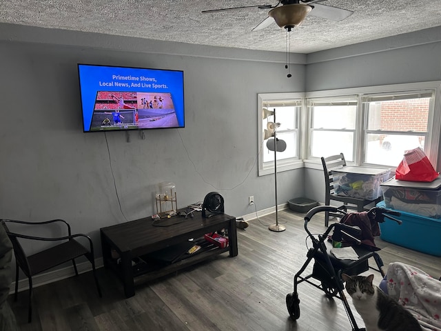 workout room featuring ceiling fan, a textured ceiling, and wood-type flooring