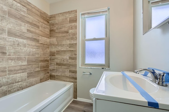 bathroom featuring hardwood / wood-style flooring, plenty of natural light, toilet, and vanity