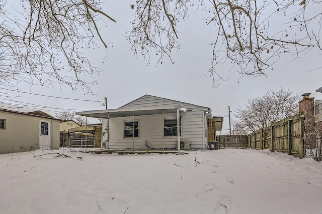 view of snow covered rear of property