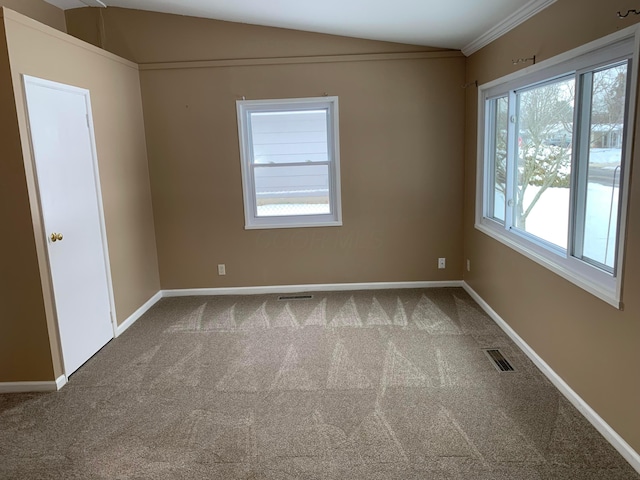 carpeted empty room featuring vaulted ceiling