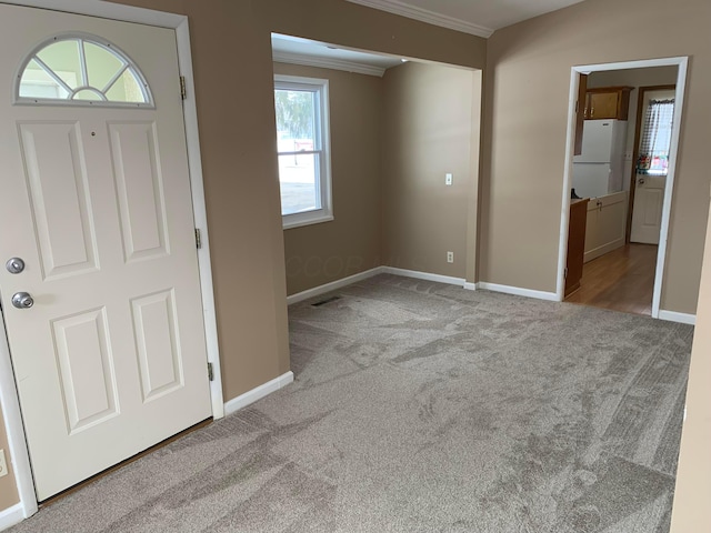 carpeted entryway featuring crown molding