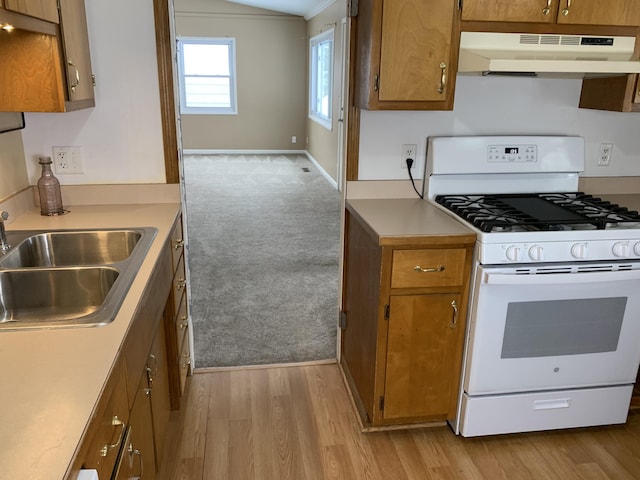 kitchen with lofted ceiling, sink, white range with gas stovetop, and light wood-type flooring