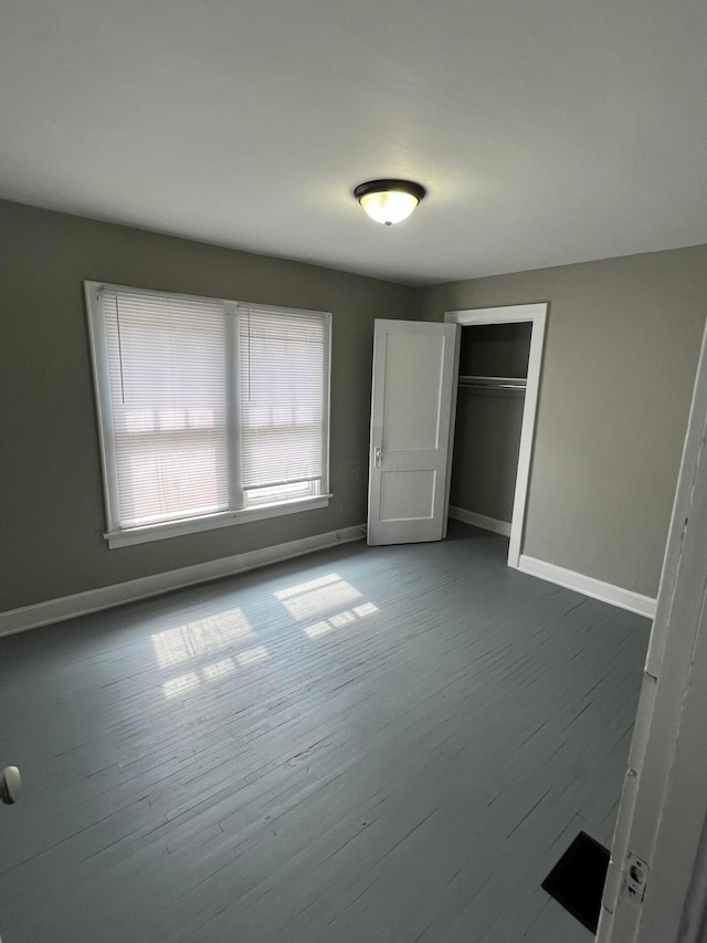 unfurnished bedroom with hardwood / wood-style flooring and a closet