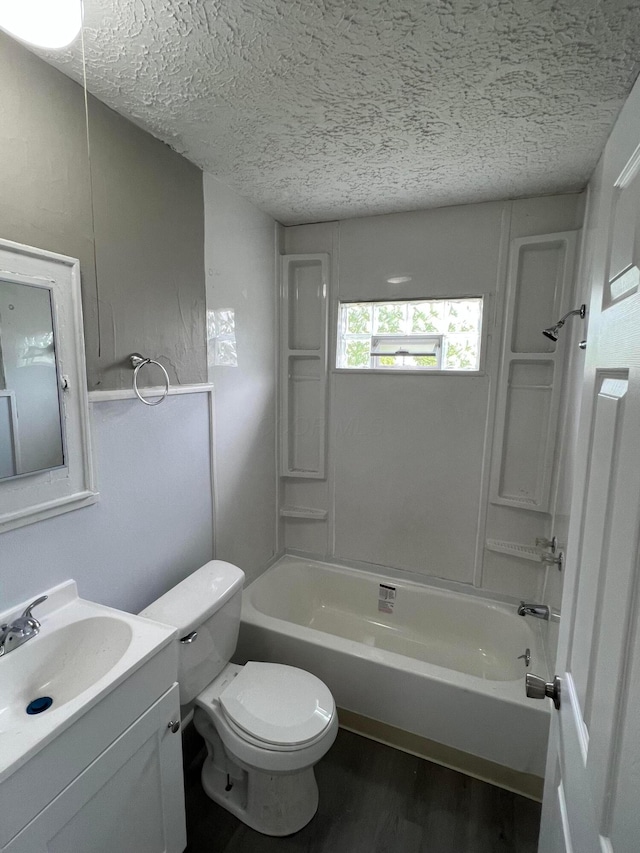 full bathroom featuring shower / bathtub combination, vanity, a textured ceiling, and toilet