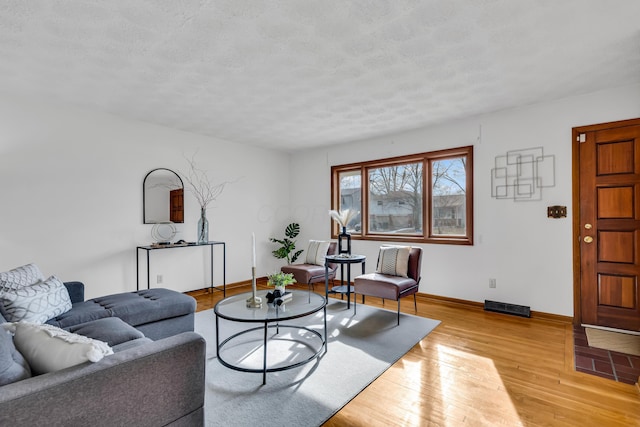 living room with light hardwood / wood-style floors and a textured ceiling