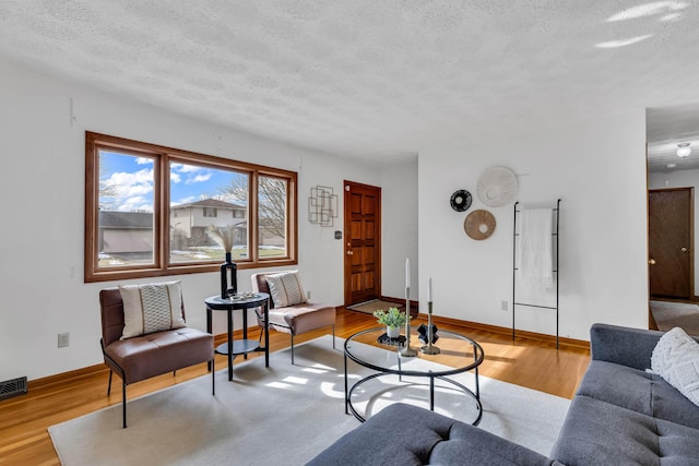 living room featuring a textured ceiling and light wood-type flooring