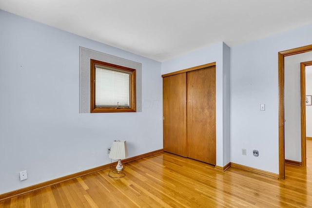 unfurnished bedroom with light hardwood / wood-style flooring and a closet