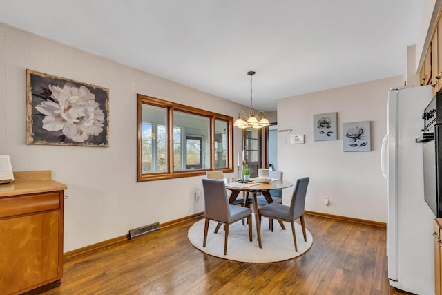 dining room with wood-type flooring and a chandelier