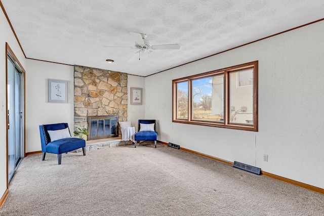 unfurnished room featuring a fireplace, carpet, ceiling fan, crown molding, and a textured ceiling