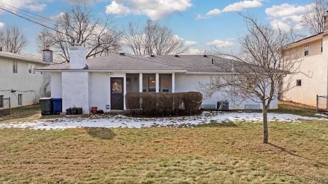 rear view of property with a yard and central air condition unit